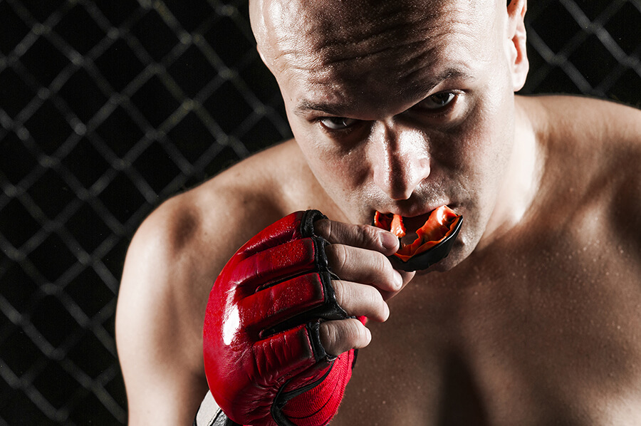 MMA fighter putting on a custom-fitted mouthgaurd