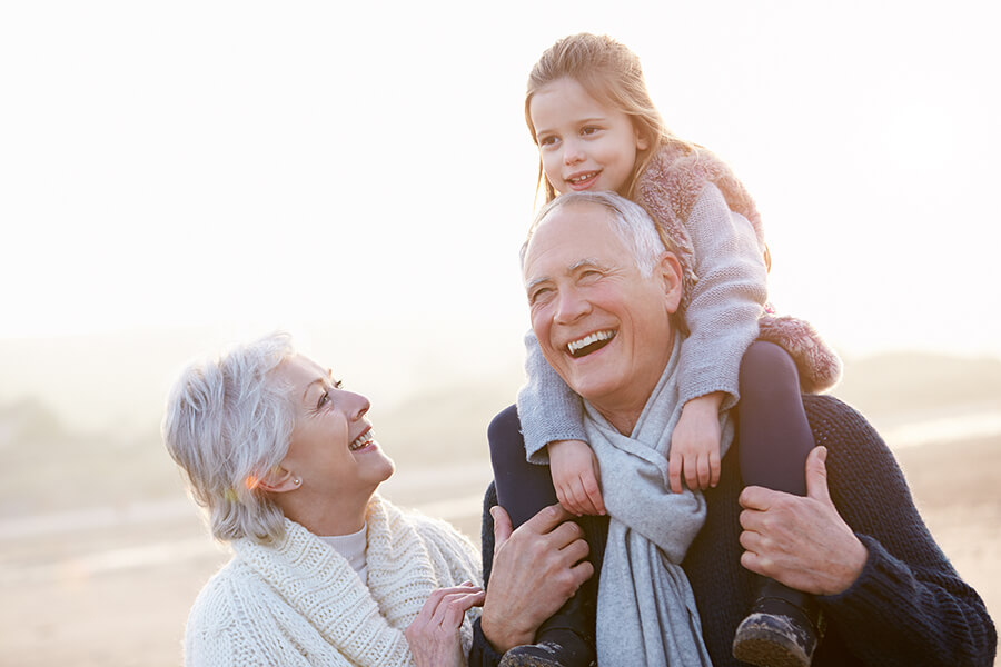 Smiling elderly couples with their granddaughter